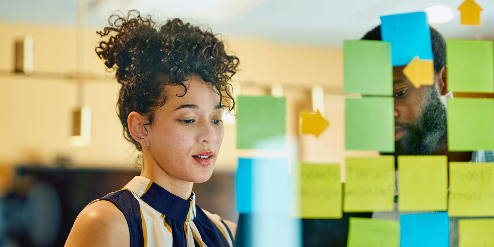 Woman putting post it notes on presentation board