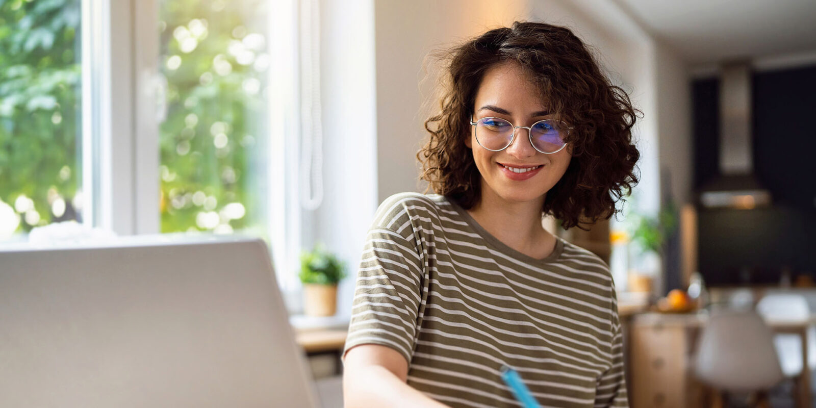 Woman making notes in book while doing homework