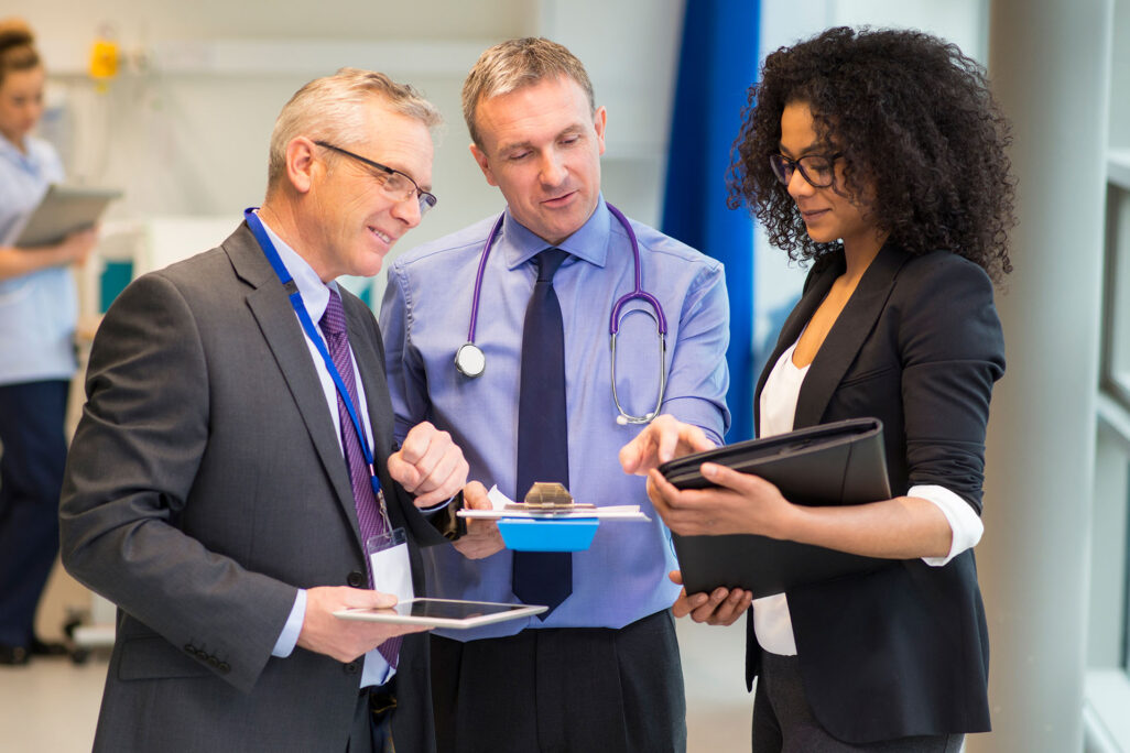 Business professionals and health educators consulting information on tablet