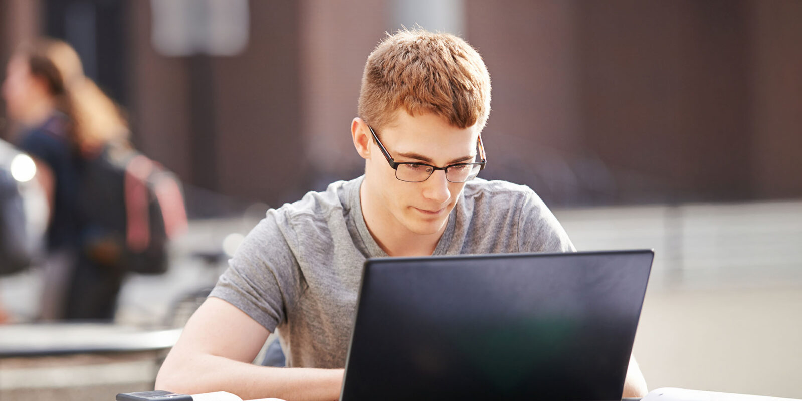 bdt_ose_hero Benedictine University student outside at table with laptop